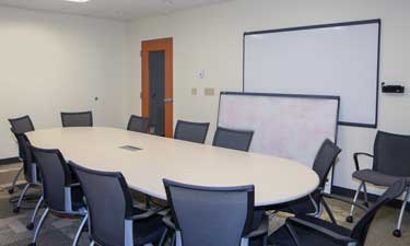 Spacious conference room with natural light and state-of-the-art AV equipment for seamless virtual meetings